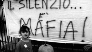 Palermo , September 1993 - Demo against the killing of Father Puglisi - A female child in front of a banner with the writing " Silence is Mafia " Palermo , settembre 1993 - Protesta contro la mafia per l'uccisione di Padre Pugliesi - Una bambina di fronte ad uno striscione con la scritta " Il silenzio  mafia " *** Local Caption *** 00127716